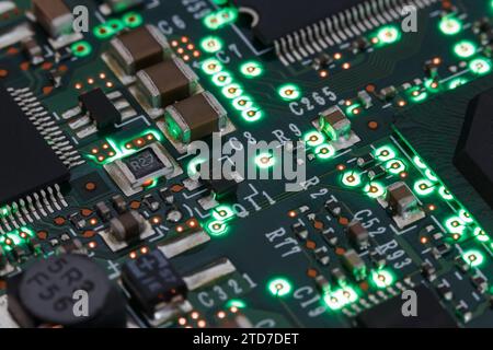 Carte de circuit imprimé avec divers éléments, avec éclairage vert. Macrophotographie Banque D'Images