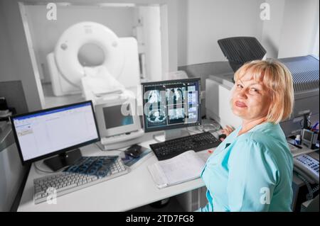 Scanner médical de tomodensitométrie ou IRM. Portrait d'une infirmière travaillant à l'ordinateur, faisant de l'IRM. Femme portant un uniforme bleu. Concept de médecine et d'hôpital. Banque D'Images