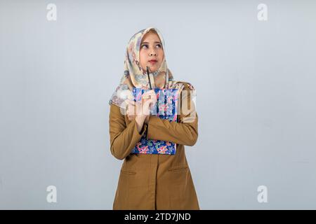 Jeune femme indonésienne employée du gouvernement portant un uniforme brun. Banque D'Images