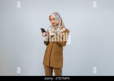 Jeune femme indonésienne employée du gouvernement portant un uniforme brun. Banque D'Images