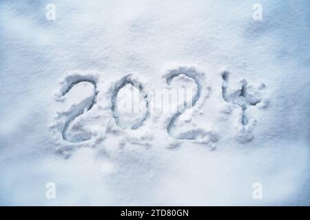 Numéro 2024 pour la nouvelle année manuscrite dans la neige, date du calendrier et symbole des fêtes, espace de copie, foyer sélectionné Banque D'Images