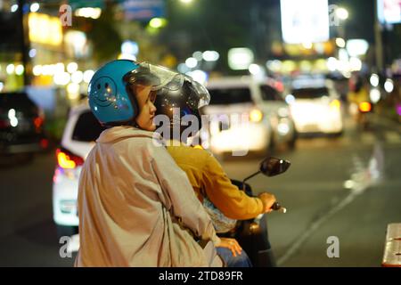 9 décembre 2023. Batu City, Java oriental, Indonésie. La vie nocturne dans la rue de la ville avec le trafic occupé le samedi soir. Banque D'Images