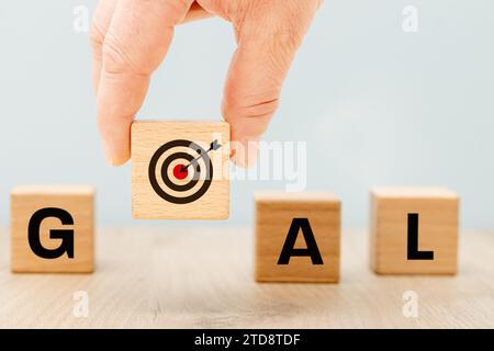 Symbole de but Un dé levé avec une cible et une flèche au milieu, formant le mot «but». Beau fond bleu. Concept d'entreprise, cadre et Banque D'Images