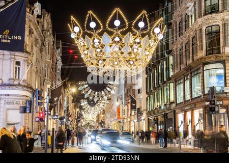 LONDRES, Royaume-Uni - 18 NOVEMBRE 2023 : décorations de Noël festives le long de New Bond Street dans le centre de Londres pendant les vacances. Les gens et la circulation peuvent être vus Banque D'Images