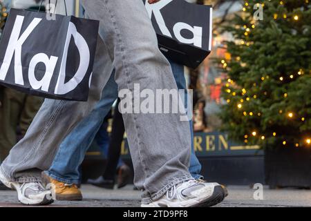 Weihnachtseinkäufe am Dritten Avent in Berlin Berlin, Deutschland - 17. Décembre 2023 : Menschen mit Einkaufstaschen vom Kaufhaus KaDeWe erledigen Weihnachtseinkäufe auf einer bekannten Einkaufsstraße, der Tauentzienstraße, Am dritten Avent in Berlin. Berlin Banque D'Images