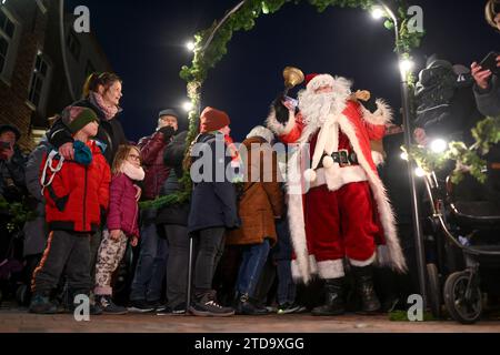 Greetsiel, Allemagne. 17 décembre 2023. Arrivé sur le bateau de pêche, le Père Noël débarque et est accueilli par les enfants. Le troisième week-end de l'Avent, il arrive traditionnellement dans le port et continue ensuite vers le 'Lüttje Greetmer Wiehnachtsmarktt' accompagné par les pompiers des jeunes. Crédit : Lars Penning/dpa/Alamy Live News Banque D'Images