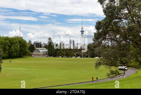 Auckland, Nouvelle-Zélande des terrains de sport avec une serre de jardin botanique conservatoire dans les jardins d'hiver du domaine d'Auckland et le bâtiment Sky Tower Banque D'Images