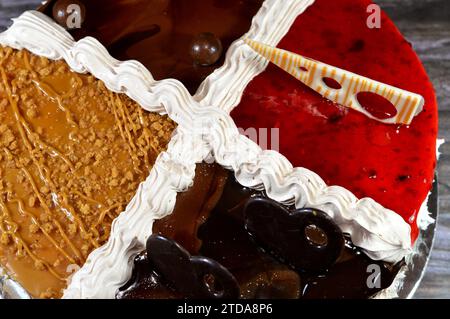Un gâteau d'anniversaire, quatre quartiers différents gâteau crémeux spongieux pour les célébrations, biscuits et crème, pâte à tartiner au chocolat aux noisettes, baies, chocolat, caram Banque D'Images