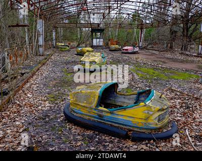 Une voiture pare-chocs jaune rouillée et abandonnée avec des sièges vides entourés d'une végétation envahie. Banque D'Images