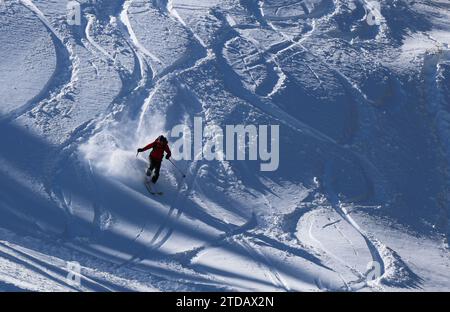 Météo hivernale en Bulgarie. Un skieur descend une piste de ski avec de la neige neuve. Banque D'Images