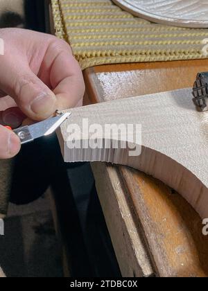 violon fabricant artisan coupe filet ronfling avec outil pour joindre l'autre côté du bord dans l'image haute résolution de canal incrusté Banque D'Images