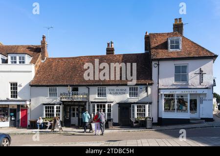 Les gens assis dehors au soleil au Horse and Groom, un pub de style rustique et restaurant avec de vraies bières sur Broad Street à New Alresford, Royaume-Uni Banque D'Images