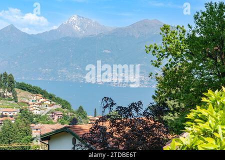 Vue sur les toits et le bleu du lac de Côme aux montagnes italiennes pittoresques, Banque D'Images