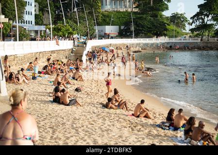 Salvador, Bahia, Brésil - 05 janvier 2022 : des touristes sont vus assis sur le sable de la plage de Porto da Barra dans la ville de Salvador, Bahia. Banque D'Images