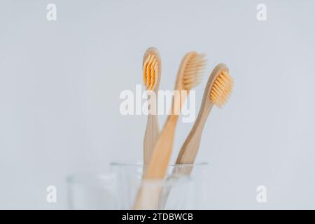 Brosse à dents.nettoyage des dents.brosse à dents dans la salle de bain. Main prend une brosse à dents d'une tasse en verre transparent sur l'évier dans une salle de bains lumineuse.hygiène humaine Banque D'Images