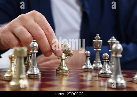 Homme déplaçant chevalier sur l'échiquier, vue rapprochée Banque D'Images
