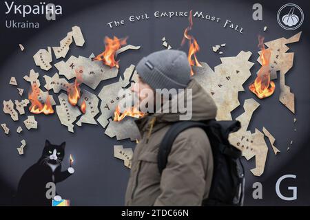 Kiev, Ukraine. 16 décembre 2023. Un homme marche près d'une maquette d'un timbre-poste avec l'inscription "l'Empire du mal doit tomber" et brûle les terres russes dans le centre de Kiev. Crédit : SOPA Images Limited/Alamy Live News Banque D'Images