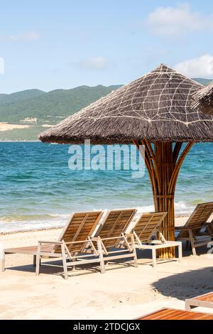 Parasols et chaises de plage contre l'océan bleu. Banque D'Images