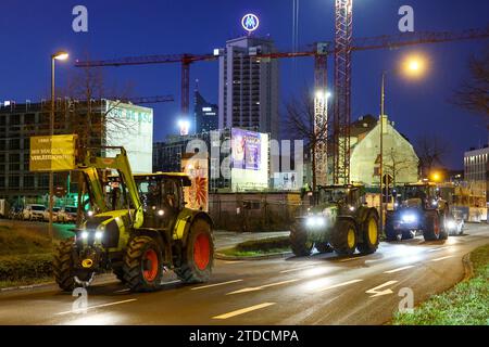 Leipzig, Allemagne. 18 décembre 2023. Plusieurs agriculteurs conduisent leurs tracteurs dans la circulation aux heures de pointe tôt le matin. Les agriculteurs veulent se mobiliser lundi à Berlin pour protester contre la suppression prévue des allégements fiscaux par la coalition des feux de circulation. Sous le slogan "trop c'est trop", un rassemblement est prévu à la porte de Brandebourg dans la matinée. Crédit : Jan Woitas/dpa/Alamy Live News Banque D'Images