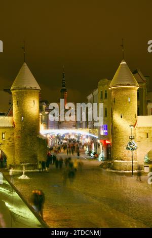 Tours en pierre de la porte Viru avec des centaines de clients et des foules festives marchant (motion blur) vers le marché de Noël dans la vieille ville de Tallinn, Estonie Banque D'Images