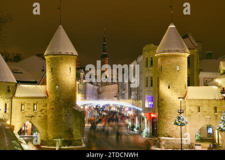 Tours en pierre de la porte Viru avec des centaines de clients et des foules festives marchant (motion blur) vers le marché de Noël dans la vieille ville de Tallinn, Estonie Banque D'Images