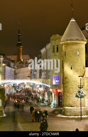 Tours en pierre de la porte Viru avec des centaines de clients et des foules festives marchant (motion blur) vers le marché de Noël dans la vieille ville de Tallinn, Estonie Banque D'Images