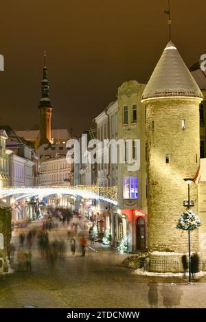 Tours en pierre de la porte Viru avec des centaines de clients et des foules festives marchant (motion blur) vers le marché de Noël dans la vieille ville de Tallinn, Estonie Banque D'Images