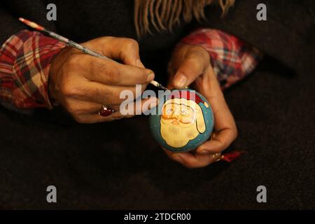 Srinagar Cachemire, Inde. 16 décembre 2023. Un artisan cachemiri peint une boule de Noël à l'atelier avant les célébrations de Noël à Srinagar. Les artisans disent que les articles de Noël sont faits de papier-mache et sont envoyés sur les marchés locaux et également exportés aux États-Unis, Italie, Allemagne, France, Canada, Australie et de nombreuses autres parties du monde. Le 16 décembre 2023, Srinagar Cachemire, Inde. (Image de crédit : © Firdous Nazir/eyepix via ZUMA Press Wire) USAGE ÉDITORIAL SEULEMENT! Non destiné à UN USAGE commercial ! Banque D'Images