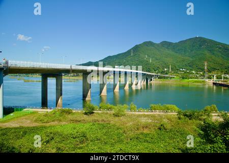 Hanam City, Corée du Sud - 1 octobre 2023 : le pont Paldang enjambe le fleuve Han sous un ciel bleu, la montagne Yebongsan s'élevant au loin, entrant Banque D'Images