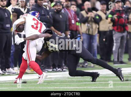 La Nouvelle-Orléans, États-Unis. 17 décembre 2023. Le cornerback Isaac Yiadom (27) des Saints de la Nouvelle-Orléans affronte le rallye des Giants de New York Matt Breida (31) près de la ligne de touche lors d'un match de la National football League au Caesars Superdome à la Nouvelle-Orléans, en Louisiane, le dimanche 17 décembre 2023. (Photo de Peter G. Forest/Sipa USA) crédit : SIPA USA/Alamy Live News Banque D'Images