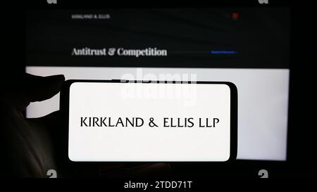 Personne tenant un téléphone portable avec le logo du cabinet d'avocats américain Kirkland et Ellis LLP devant la page Web de l'entreprise. Concentrez-vous sur l'affichage du téléphone. Banque D'Images