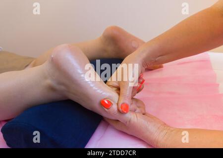 Séance de massage naturopathique dans un studio de thérapie naturelle. Le thérapeute utilise des techniques holistiques pour favoriser la relaxation et le bien-être. Banque D'Images