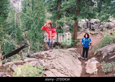 Mère et fille marchant ensemble sur un sentier forestier Banque D'Images