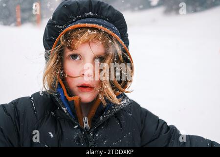 Fille aux cheveux roux portant des vêtements chauds dans la neige Banque D'Images