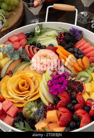 Plateau de fête de fruits tranchés avec des fleurs Banque D'Images