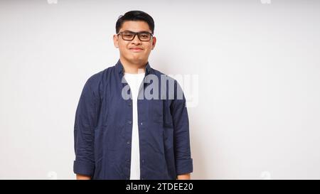 Souriant jeune homme asiatique portant une chemise décontractée sur fond blanc. prise de vue en studio Banque D'Images