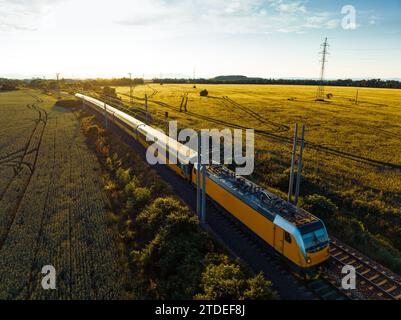 Vue aérienne du train au milieu de la nature, champ, pendant la journée ensoleillée d'automne. Banque D'Images