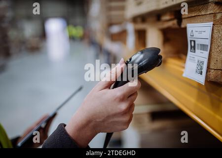 Scanner, scannant les codes-barres sur les produits dans l'entrepôt. Gestionnaire d'entrepôt utilisant un système de balayage d'entrepôt. Banque D'Images