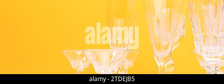 Bannière avec verres en cristal vintage devant fond jaune. Banque D'Images