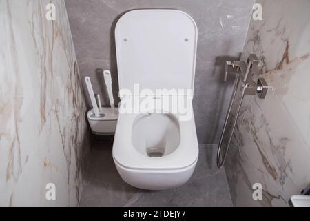 toilettes murales modernes dans la salle de bain avec carreaux de grès cérame gris. Brosses hygiéniques pour douches et toilettes. Banque D'Images