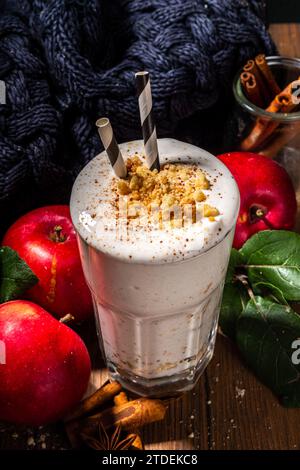 Milk-shake aux pommes chargé maison, smoothie aux protéines de pomme d'automne rouge avec crumble à la tarte et épices, boisson de petit-déjeuner de saison d'automne saine, sur W confortable Banque D'Images