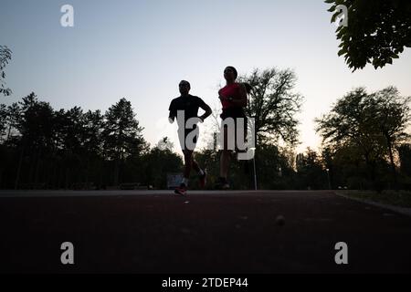 Jogging couple attrayant ensemble, corps en forme dans le cadre du parc naturel. Banque D'Images