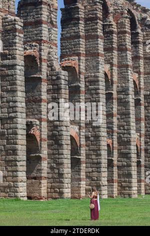 Merida, Espagne - 4 juin 2023 : jeune femme reenactor à côté de l'aqueduc Los Milagros. Emerita Ludica Festival 2023, Mérida, Espagne Banque D'Images