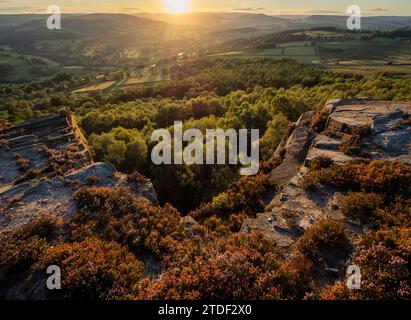 Vue sur Hathersage et Hope Valley dans la lumière du soleil du soir de Millstone Edge avec la bruyère fleurie, Peak District National Park, Derbyshire Banque D'Images