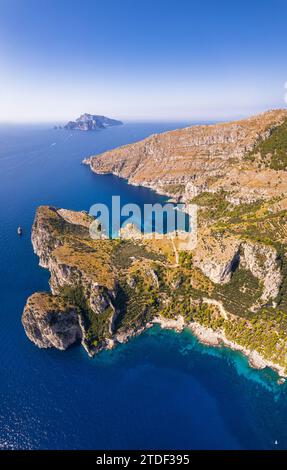Vue panoramique de la rive rocheuse de Punta Campanella et de la baie d'Ieranto avec l'île de Capri en arrière-plan, côte amalfitaine Banque D'Images