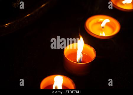 Cliché de nuit des flammes des bougies de cimetière en verre debout sur les pierres tombales. Le tir a été pris pendant la Toussaint, le 1 novembre. Banque D'Images