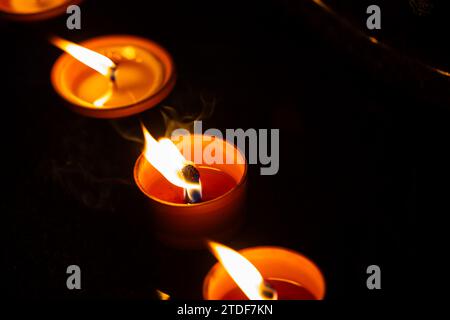 Cliché de nuit des flammes des bougies de cimetière en verre debout sur les pierres tombales. Le tir a été pris pendant la Toussaint, le 1 novembre. Banque D'Images