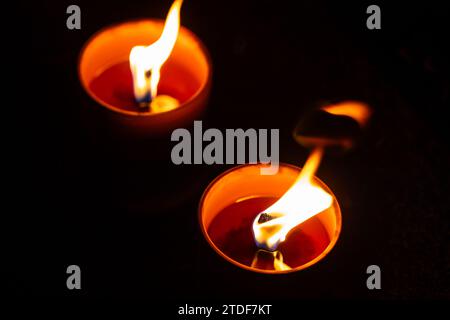 Cliché de nuit des flammes des bougies de cimetière en verre debout sur les pierres tombales. Le tir a été pris pendant la Toussaint, le 1 novembre. Banque D'Images