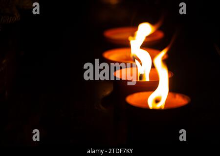 Cliché de nuit des flammes des bougies de cimetière en verre debout sur les pierres tombales. Le tir a été pris pendant la Toussaint, le 1 novembre. Banque D'Images