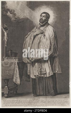 Saint François Xavier avec une lumière divine émanant vers lui par le haut à gauche, avec un crucifix, une mitre et un livre sur une table à gauche 1951 par Schelte Adams a Bolswert Banque D'Images